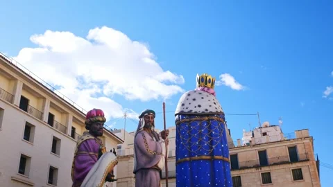 Clouds passing behind the three giant wise men at the town hall square Stock Footage 299782736