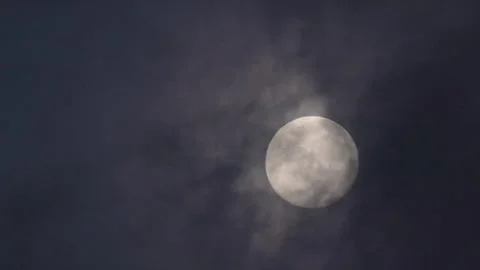 Clouds passing by in front of a bright almost full moon Stock Footage 341016506