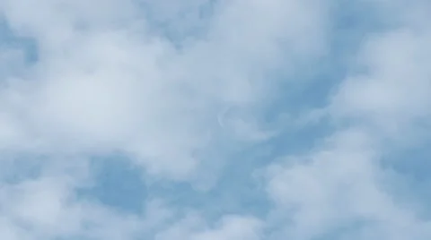 Clouds passing in front of a white moon against a blue sky Stock Footage 53240370