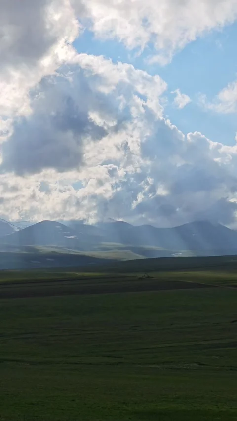 Clouds passing over green valley and snowy mountains Vidéo 311406418