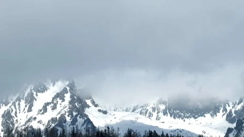 Clouds passing over high mountains covered with snow. Stock Footage 88353561