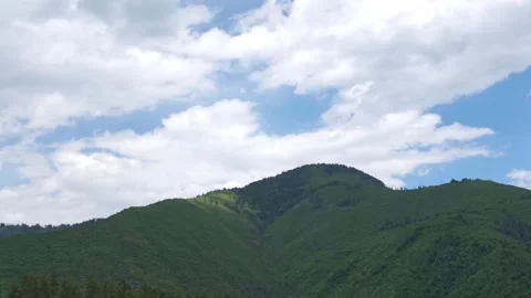 Clouds passing over lush green mountain range 库存影片 315357987