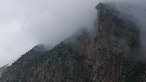 Clouds passing over mountain peak forming different shapes Video stock 289663908