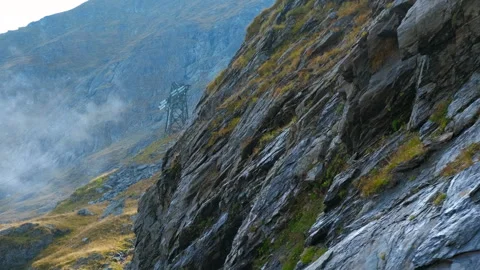 Clouds passing over mountain peak revealing power lines Stock Footage 322568120
