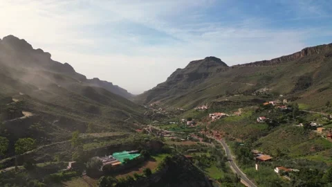 Clouds passing over mountain valley with small village Stock Footage 293158224