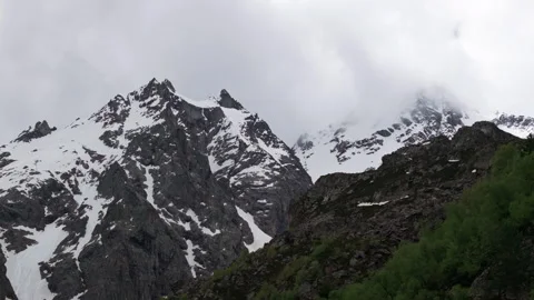 Clouds passing over snow capped mountain peaks Video stock 289652128