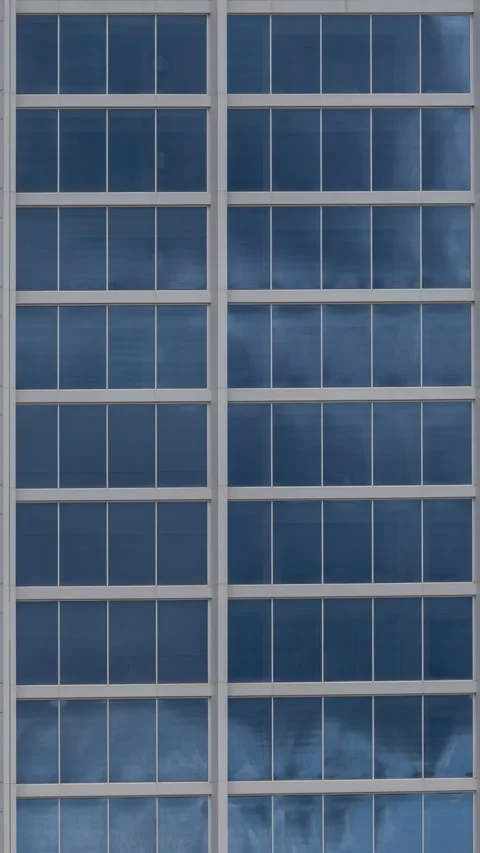 Clouds passing in reflection of glass windows of skyscraper 動画素材 283902898
