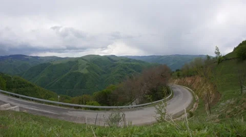 Clouds passing in speed over the high mountains with dense forests, on a road Stock Footage 62917629