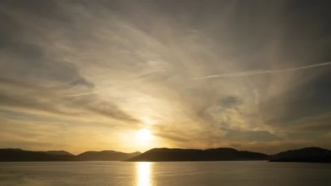 Clouds Passing Sun Setting Over A River And Hills Video stock 172058354