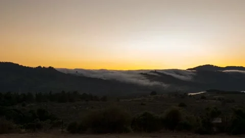 Clouds pour into the warm valley and melt in the orange Californian sky Stock Footage 130301752