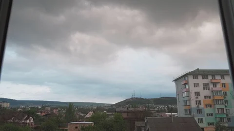 Clouds quickly fly outside the window over the city and the mountain Stock Footage 129815481