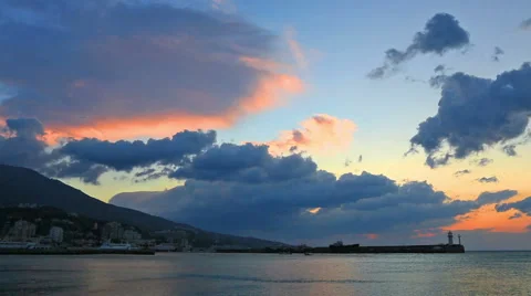 Clouds quickly move over the sea and a beacon at sunrise in Yalta, the Crimea Stock Footage 47243349