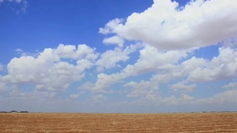 Clouds race over a plowed field in late spring, 4K. Stock Footage 140971199