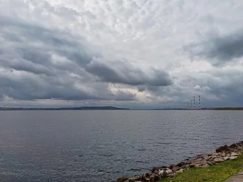 Clouds before the rain. Clouds, over the river floating low. Stock Photos