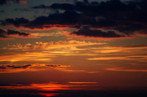 Clouds in the rays of the setting sun. Stock Photos