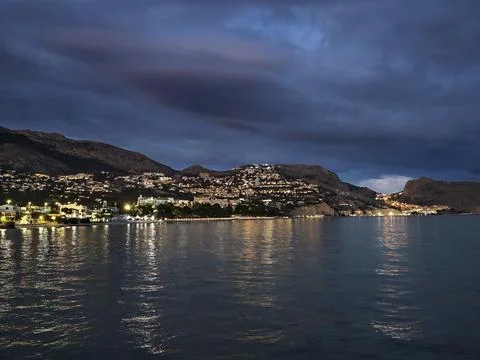 Clouds reflect on water surface, Dark clouds hang above expansive coastal l.. Stockfoto's
