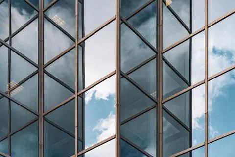 Clouds reflected on the facade of an office building Stock Photos