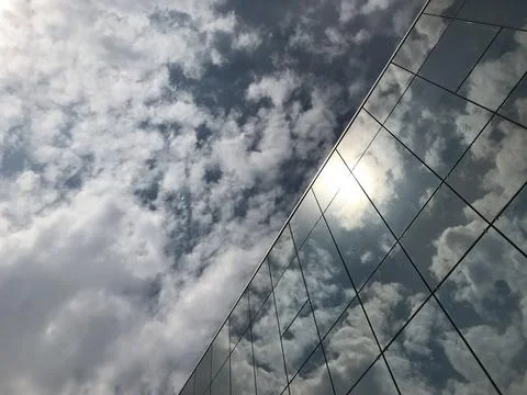 Clouds reflected in glass building Stock Photos