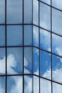 Clouds reflected in the glass facade of a skyscraper Stock Photos