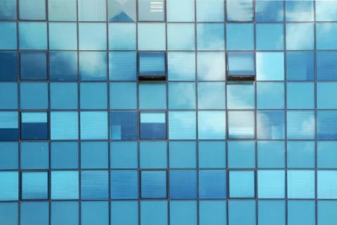 Clouds reflected in the glass facade of a skyscraper Stock Photos