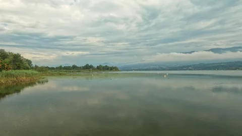 Clouds reflected on the lake water on a rainy morning Stock Footage 317346561