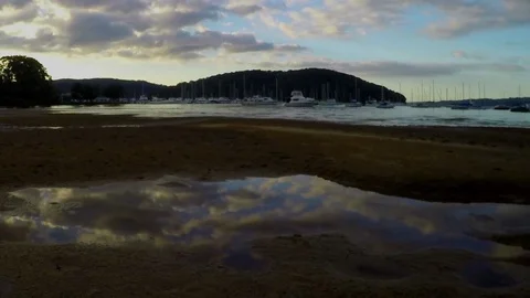 Clouds reflected in a pool of water on a sandbank. Motion time lapse. Видео 76030855