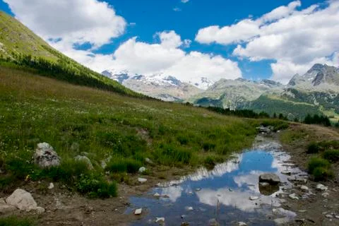 Clouds reflected in a small river in Aoste, Italy Фото