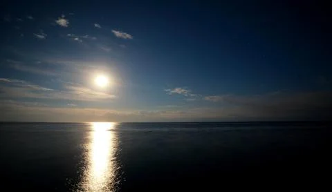 Clouds reflected on the water during sunset Stock Photos