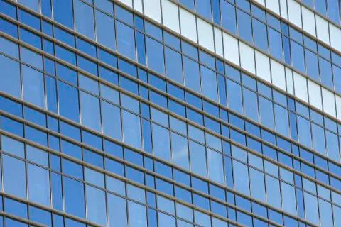 Clouds reflected in windows in the blue skyscraper office building Stock Photos