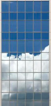 Clouds reflected in windows in the blue skyscraper office building Stock Photos