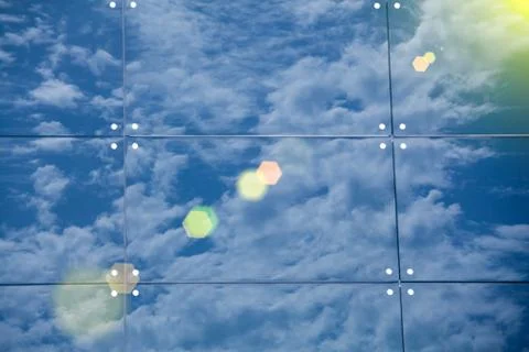 Clouds reflected in windows of modern office building Stock Photos