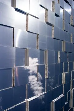 Clouds reflected in windows of modern office building Stock Photos