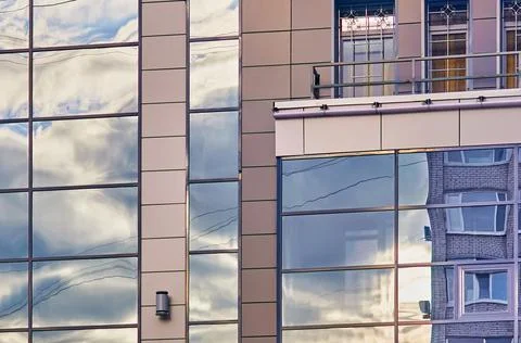 Clouds reflected in windows of modern office building Stock Photos