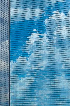 Clouds reflected in windows of skyscraper Stock Photos