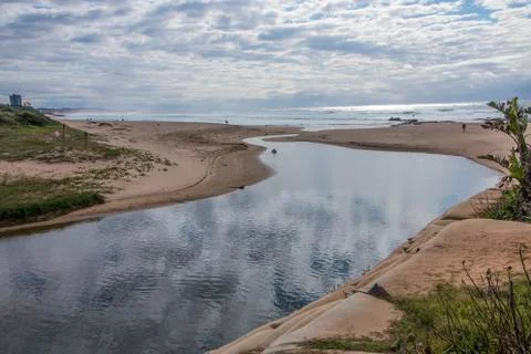 Clouds Reflecting on River Flowing into the Sea Stock Photos