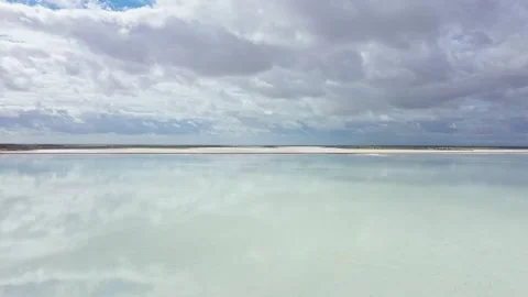 Clouds reflecting in shallow water on windy day Vídeo Stock 301907761