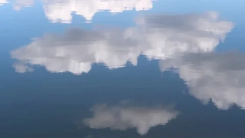 Clouds reflecting in the water against the background of the summer bare sky Stock Footage 161148905