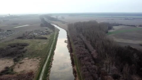 Clouds reflecting of water surface in canal in town Bac, Serbia, aerial view 스톡 동영상 258609132