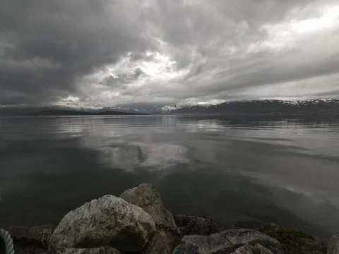 Clouds reflection, sea with snowy mountains on the horizon timelapse Stock Footage 205571883