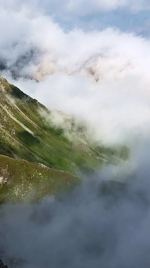 Clouds on the right moving slowly up a green mountain slope in the alps Stock Footage 248057594