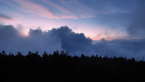 Clouds Rising Up into Mountains above a Forest Canopy at Sunset Stock Footage 96752970