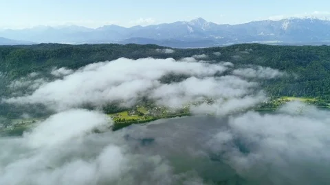 Clouds roll over alpine lake in mountains Stock Footage 102041876