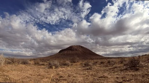 Clouds roll over barren Mojave Desert plain with single mountain, Time 스톡 동영상 121191576