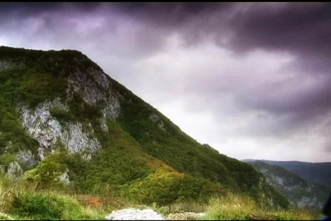 Clouds roll over a rocky cliff in the wilderness Stock-Footage 110865