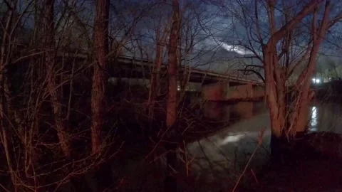 Clouds Roll by from under Bridge at night Timelapse Opening Under Moon in 4K 動画素材 189760923