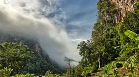 Clouds rolling across a jungle and limestone hills in Northern Thailand. Stock Footage 61793384