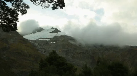 Clouds rolling across snowy mountain peaks Video stock 55529861