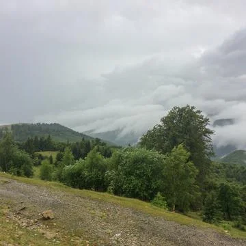 Clouds rolling over forested hills in Gorj County, Romania Stock Photos