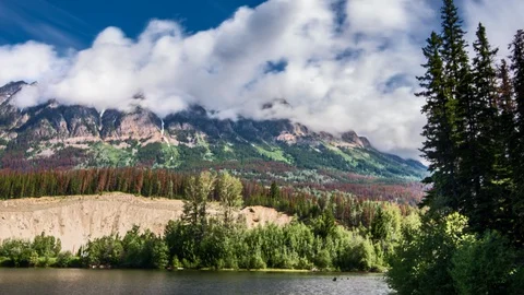 Clouds rolling over mountain top slop an up time lapse Stock Footage 128408169