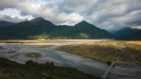 Clouds rolling over mountains with shadows. River Valley Stock Footage 132298142